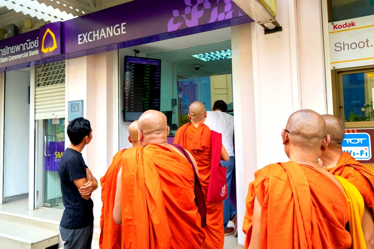 Geld regiert die Welt - thailndische buddhistische Mnche am Bankschalter
